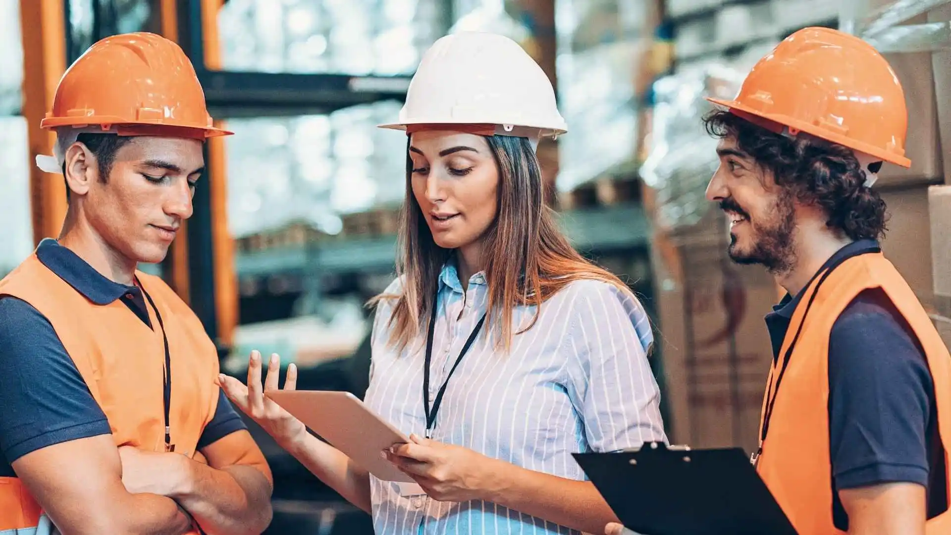 Capacitación en seguridad e higiene industrial con instructora y empleados dentro de una planta.